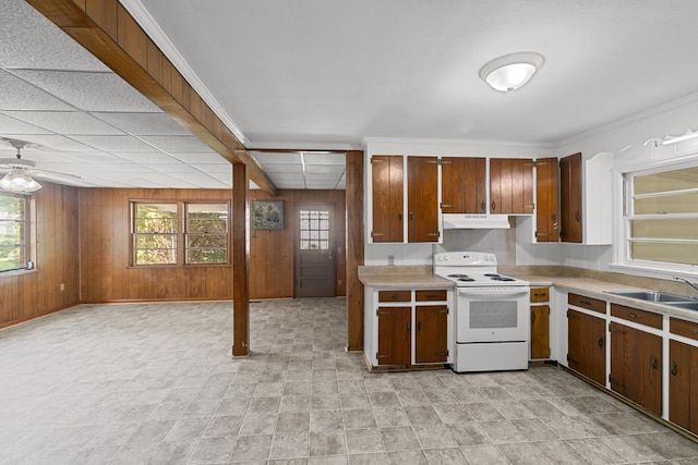 1105 Deborah St, Dothan, AL 36301 - kitchen with electric range, light countertops, wooden walls, under cabinet range hood, and plenty of natural light