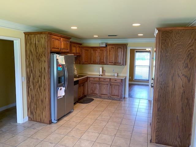 708 Sandstone Dr, Dothan, AL 36303 - kitchen with appliances with stainless steel finishes, ornamental molding, light tile patterned floors, light countertops, and brown cabinetry