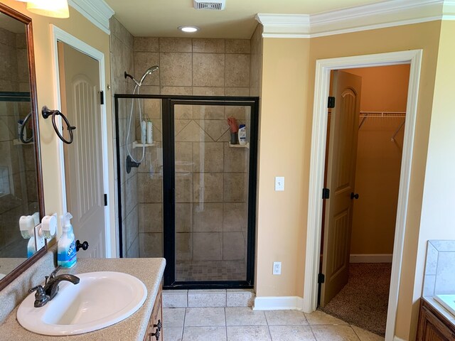 708 Sandstone Dr, Dothan, AL 36303 - full bathroom featuring vanity, a stall shower, a walk in closet, crown molding, and tile patterned floors