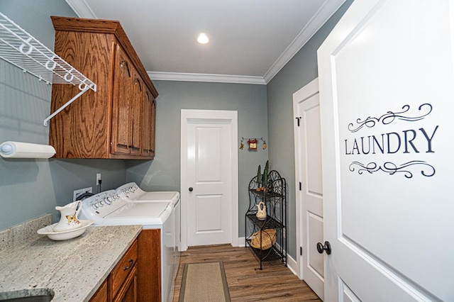 washroom featuring crown molding, dark hardwood / wood-style flooring, cabinets, and independent washer and dryer