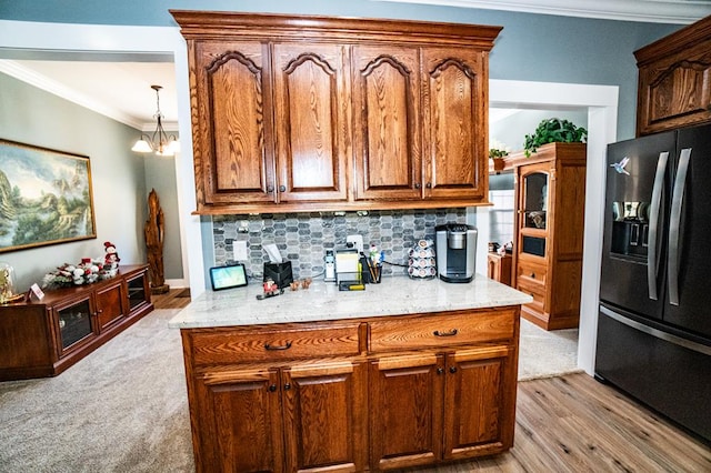 kitchen featuring decorative backsplash, stainless steel fridge, light colored carpet, crown molding, and a notable chandelier