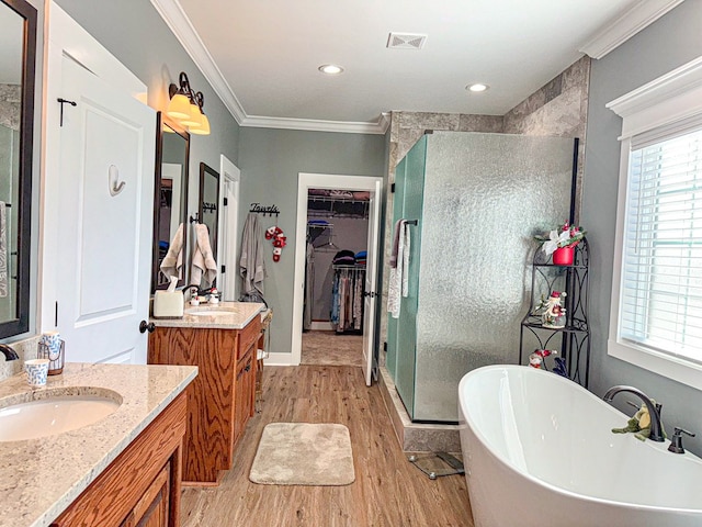 bathroom with separate shower and tub, crown molding, hardwood / wood-style floors, and vanity