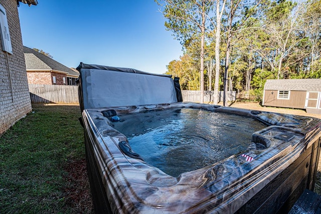 view of pool with a storage shed and a hot tub