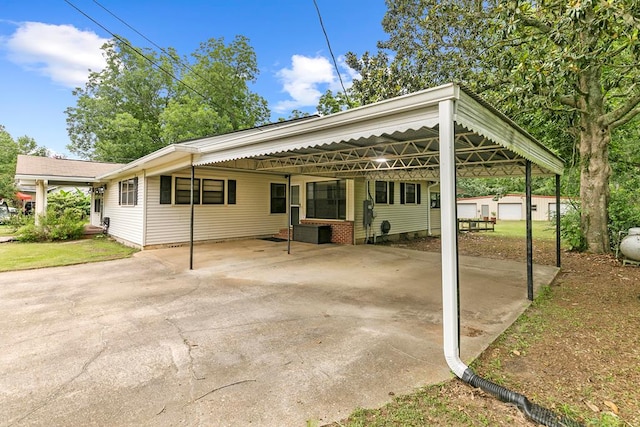 6970 Walden Dr, Kinsey, AL 36303 - view of patio / terrace featuring an outdoor structure, concrete driveway, and a carport