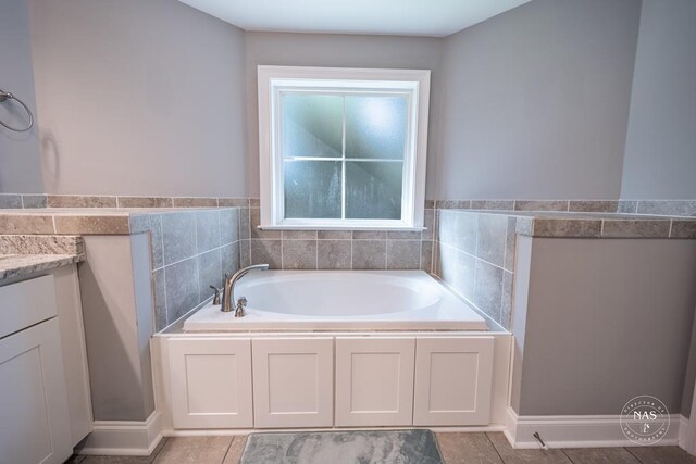 bathroom featuring a bathtub, vanity, and tile patterned flooring