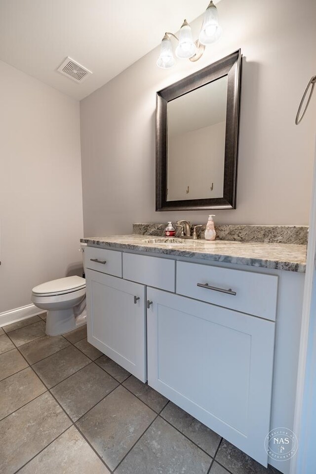 bathroom featuring tile patterned floors, vanity, and toilet