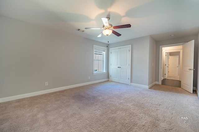 unfurnished bedroom featuring ceiling fan, a closet, and light carpet