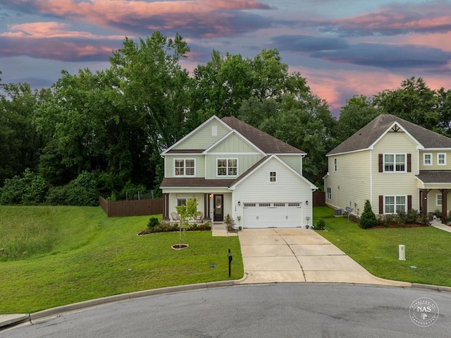 view of front of house featuring covered porch, a yard, and a garage