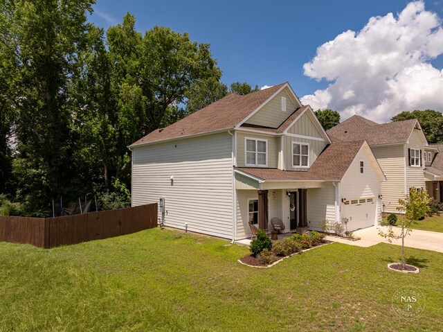 view of front of property with a front yard, a garage, and covered porch