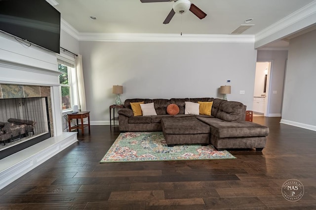 living room featuring dark hardwood / wood-style floors, ceiling fan, ornamental molding, and a tile fireplace