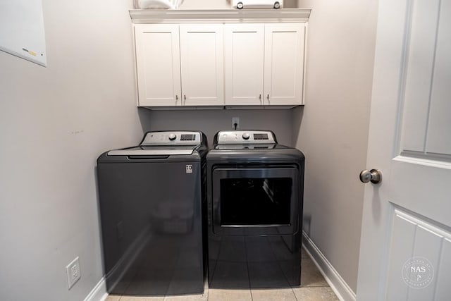 washroom with cabinets, washer and clothes dryer, and light tile patterned flooring