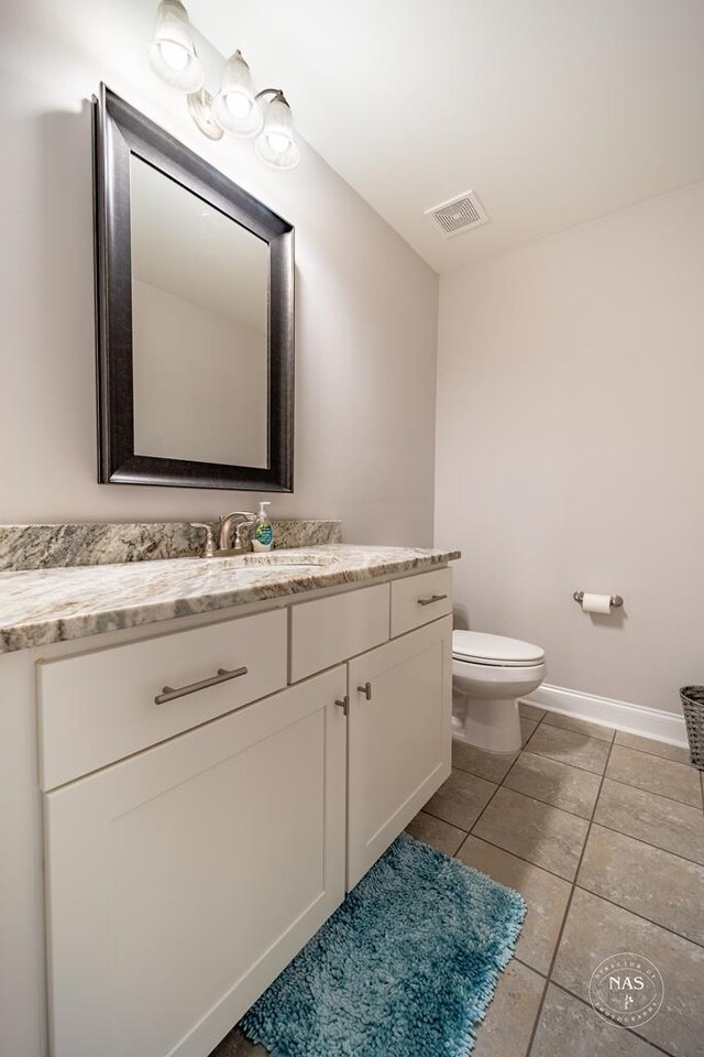 bathroom featuring tile patterned floors, vanity, and toilet