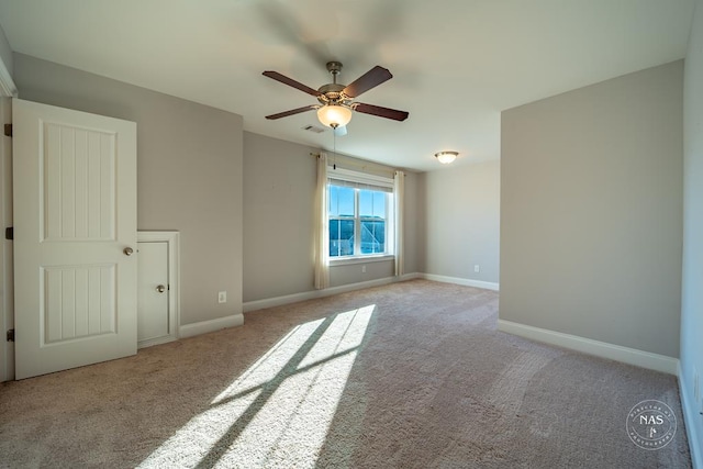 carpeted spare room with ceiling fan