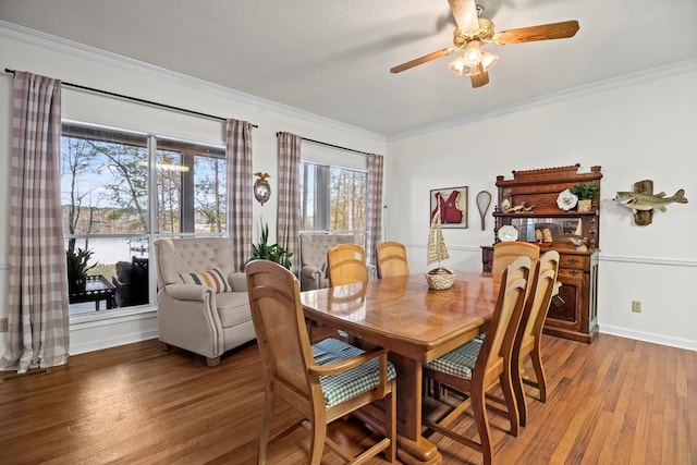 dining area with ceiling fan, hardwood / wood-style floors, a textured ceiling, and ornamental molding