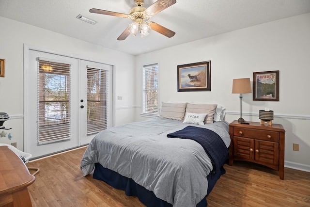 bedroom featuring access to outside, french doors, ceiling fan, a textured ceiling, and wood-type flooring