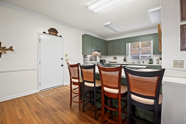 kitchen with a kitchen bar, kitchen peninsula, dark hardwood / wood-style floors, and ornamental molding