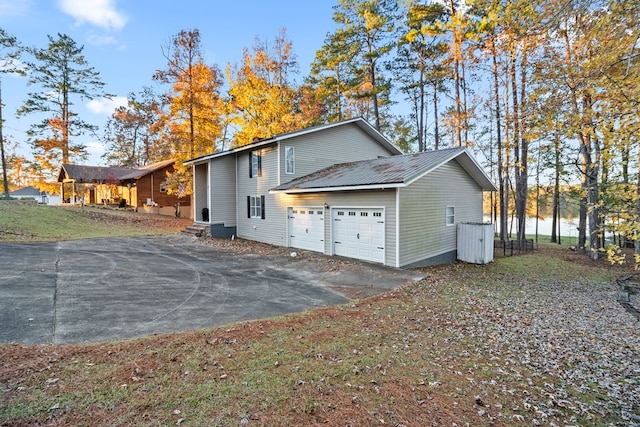 view of home's exterior featuring a water view and a garage