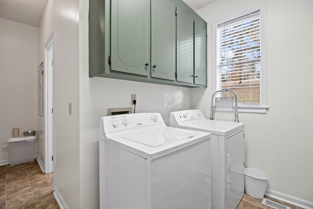 clothes washing area with cabinets and independent washer and dryer