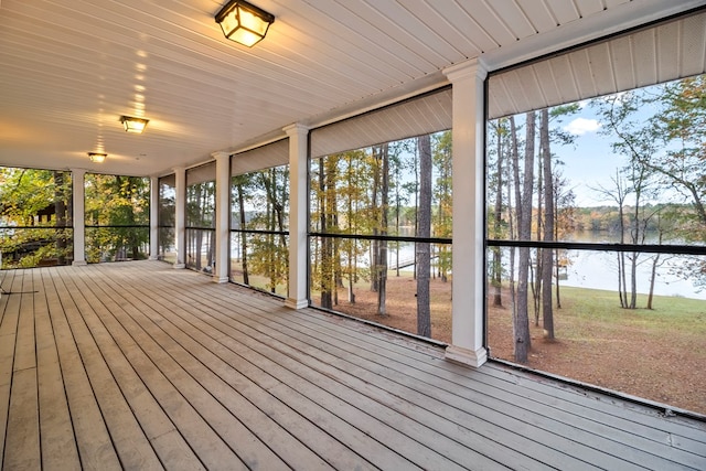 unfurnished sunroom featuring a water view