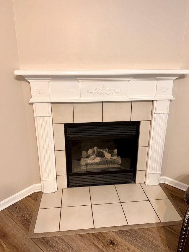 room details with a tile fireplace and wood-type flooring