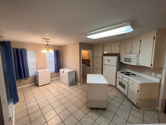 kitchen with a center island, washer / dryer, a chandelier, pendant lighting, and white appliances