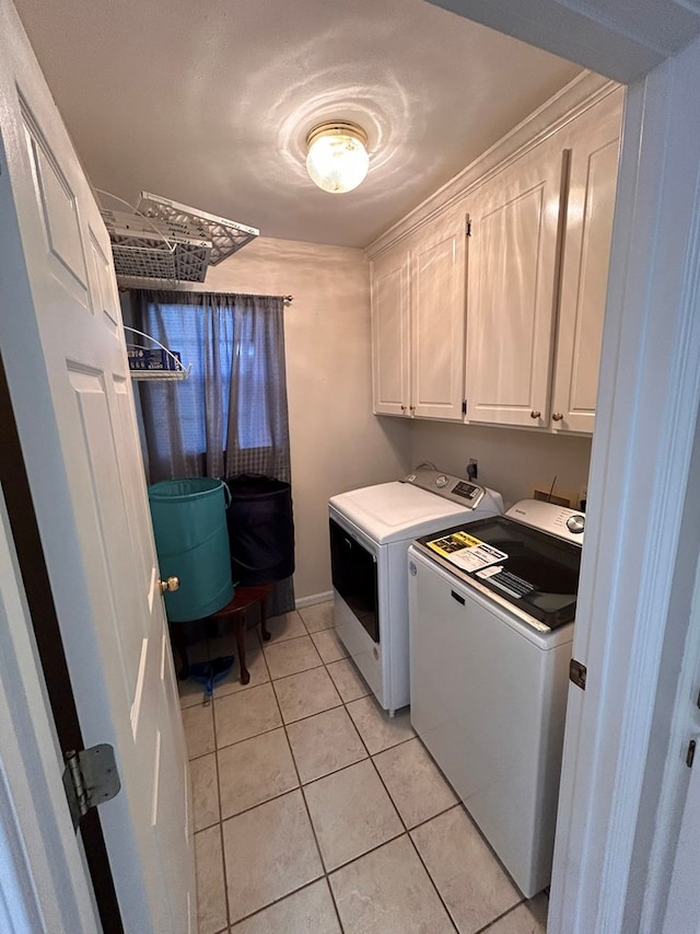 washroom with cabinets, independent washer and dryer, and light tile patterned flooring