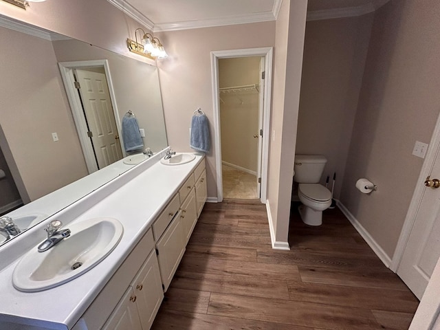 bathroom with toilet, vanity, ornamental molding, and hardwood / wood-style flooring