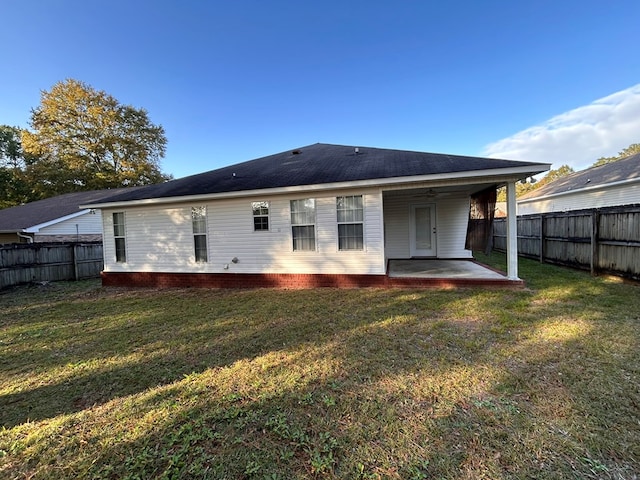 rear view of property featuring a yard, a patio, and ceiling fan