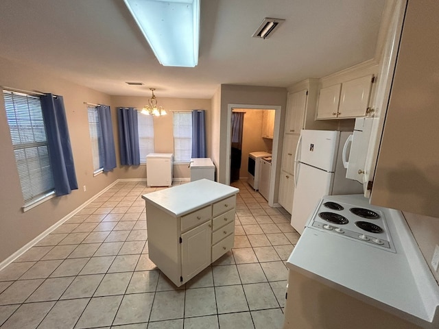 kitchen with white cabinets, a center island, hanging light fixtures, and a healthy amount of sunlight