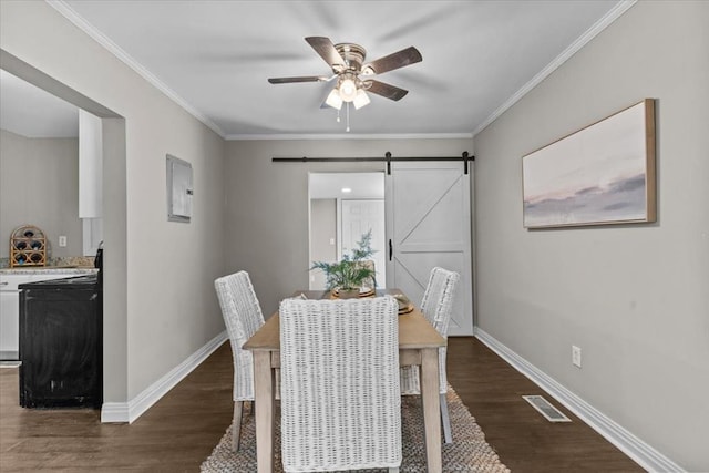 1301 S Bell St, Dothan, AL 36301 - dining space featuring a ceiling fan, a barn door, dark wood-style flooring, baseboards, and crown molding