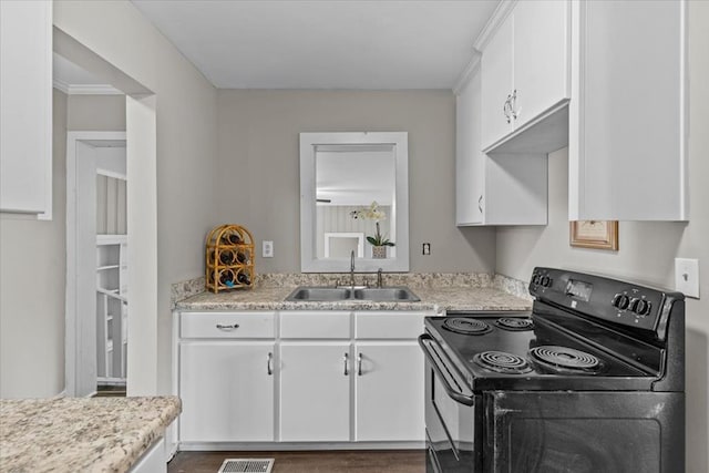 1301 S Bell St, Dothan, AL 36301 - kitchen featuring black range with electric stovetop, a sink, white cabinets, and light countertops