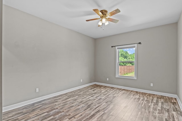 unfurnished room with ceiling fan, baseboards, and wood finished floors