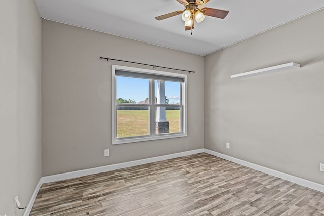 unfurnished room with baseboards, a ceiling fan, and wood finished floors
