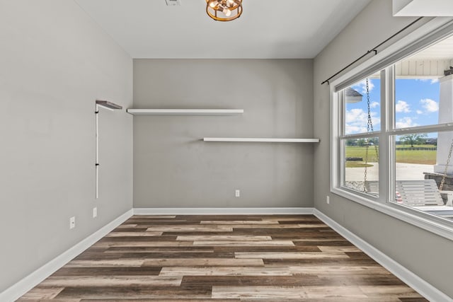 interior space featuring wood finished floors, visible vents, and an inviting chandelier