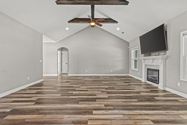 unfurnished living room with a ceiling fan, wood finished floors, a glass covered fireplace, arched walkways, and baseboards