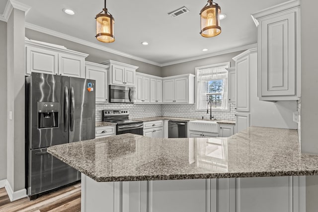 kitchen with stainless steel appliances, a peninsula, a sink, visible vents, and backsplash