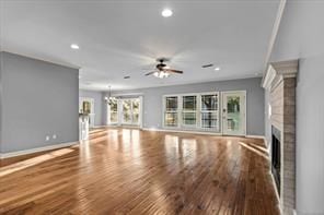 unfurnished living room featuring a fireplace, recessed lighting, a ceiling fan, wood finished floors, and baseboards