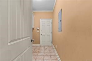 entryway featuring crown molding, baseboards, and light tile patterned floors