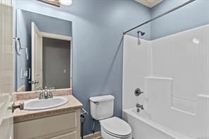 full bathroom with bathing tub / shower combination, vanity, and toilet