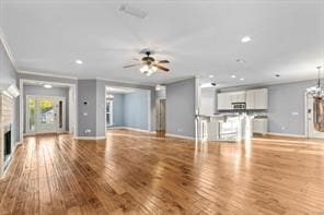 unfurnished living room with a fireplace, baseboards, and wood finished floors