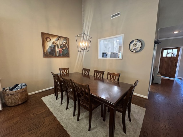 dining space featuring visible vents, baseboards, an inviting chandelier, and dark wood-style flooring