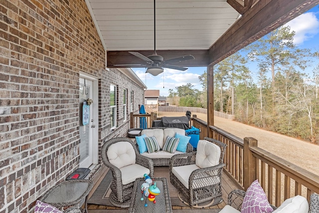 wooden terrace with ceiling fan and an outdoor living space