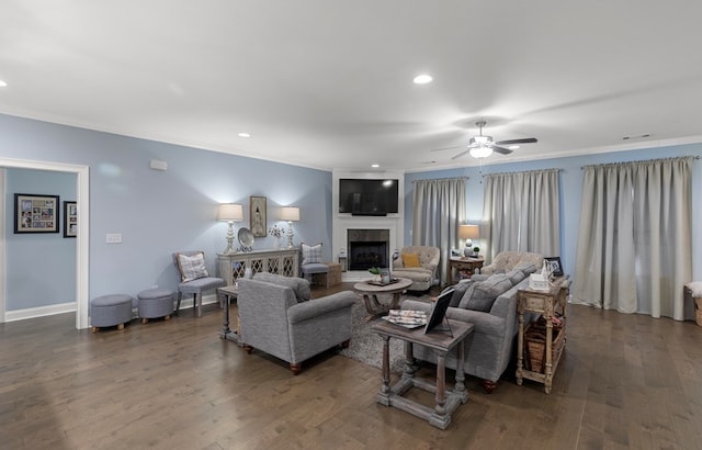 living room with a fireplace, ceiling fan, crown molding, and dark hardwood / wood-style flooring