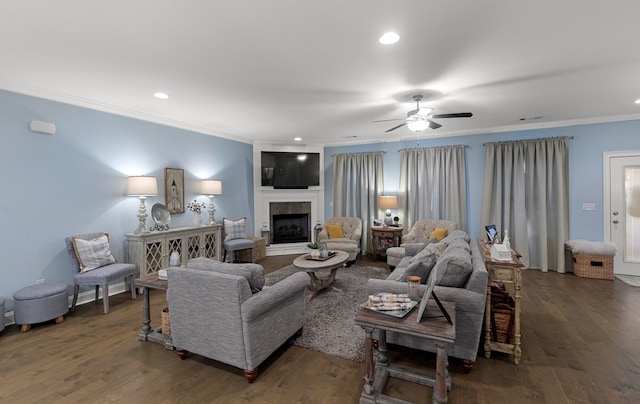 living room with dark hardwood / wood-style flooring, a fireplace, ceiling fan, and ornamental molding