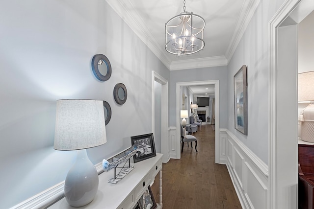 hall featuring ornamental molding, dark hardwood / wood-style flooring, and a notable chandelier