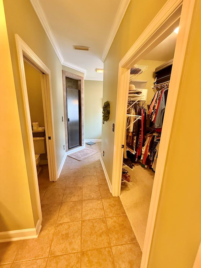 hall featuring tile patterned floors and crown molding