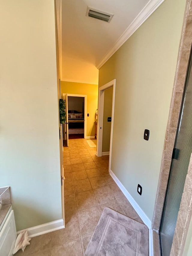 hall featuring ornamental molding and light tile patterned floors