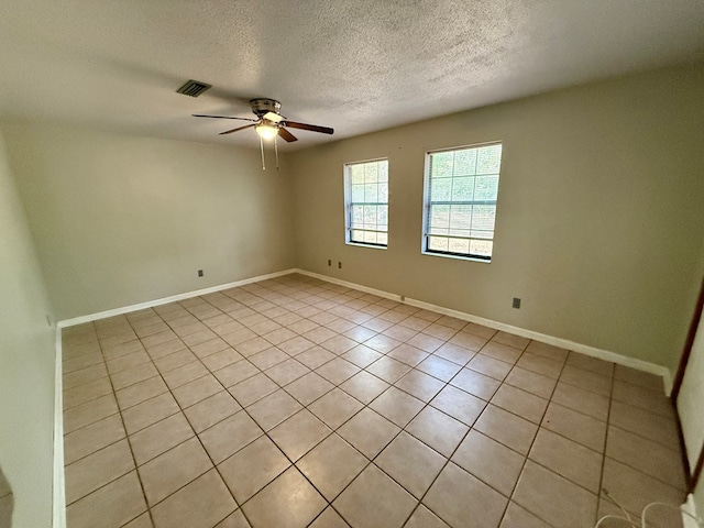 tiled spare room featuring ceiling fan and a textured ceiling