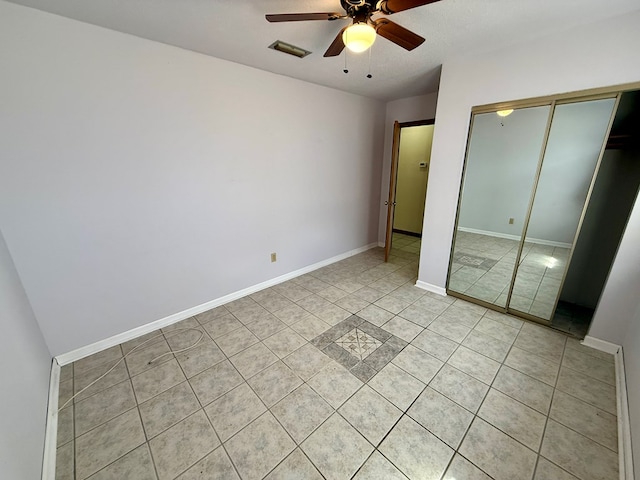 unfurnished bedroom featuring ceiling fan, light tile patterned floors, and a closet