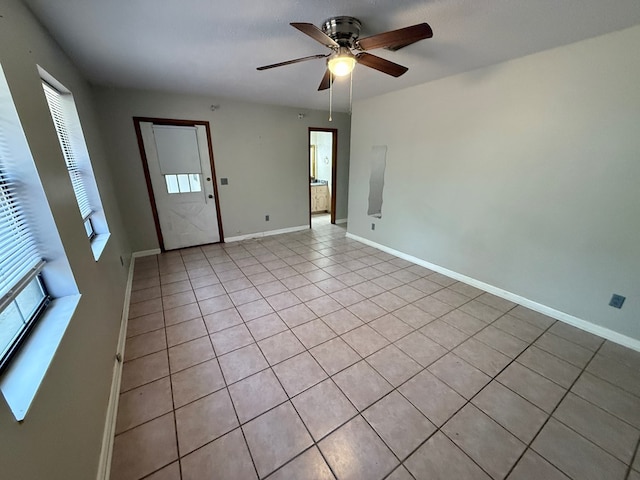 spare room with ceiling fan and light tile patterned floors